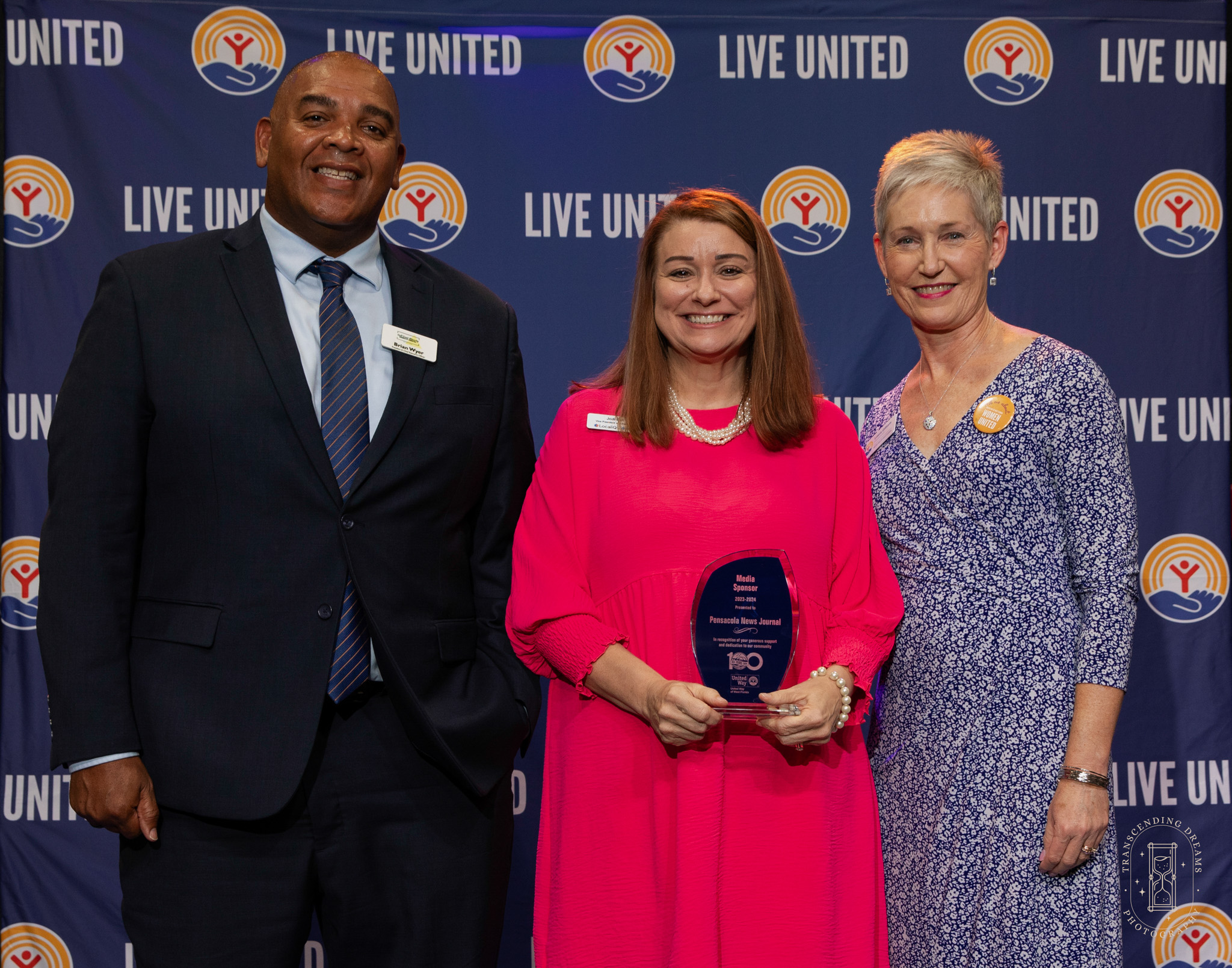 Brian Wyer, Jodi Bell, and Laura, with award thanking Pensacola News Journal for their media partnership for 2023-2024