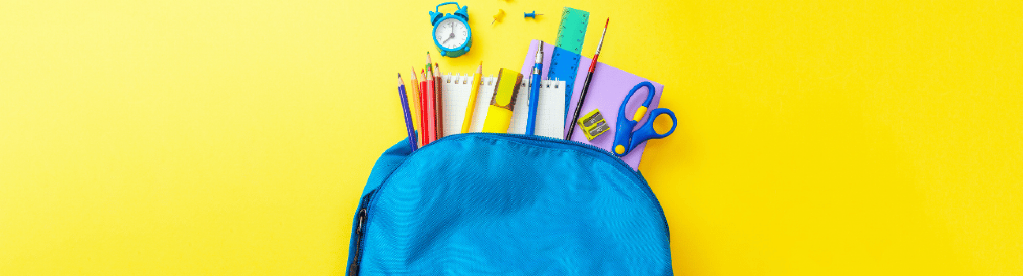 Blue Backpack spilling over with school supplies over a yellow background